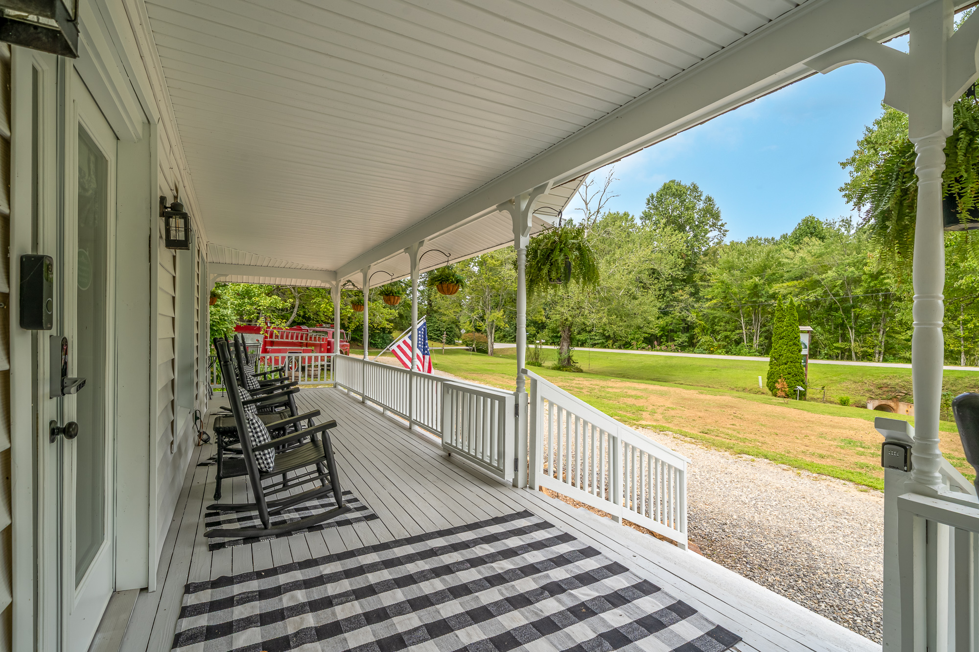 Wraparound porch with rocking chairs and mountain view